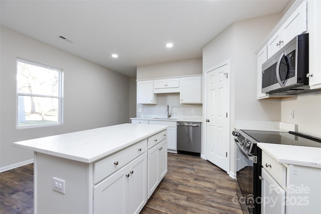 kitchen featuring sink, stainless steel appliances, a kitchen island, dark hardwood / wood-style flooring, and white cabinets