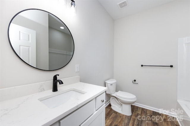 bathroom with wood-type flooring, vanity, and toilet