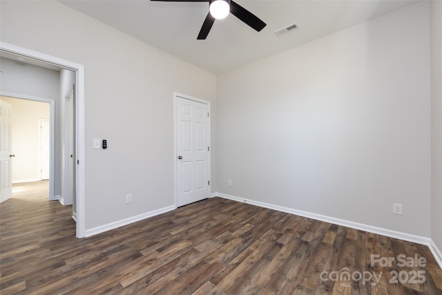 empty room featuring ceiling fan and dark wood-type flooring