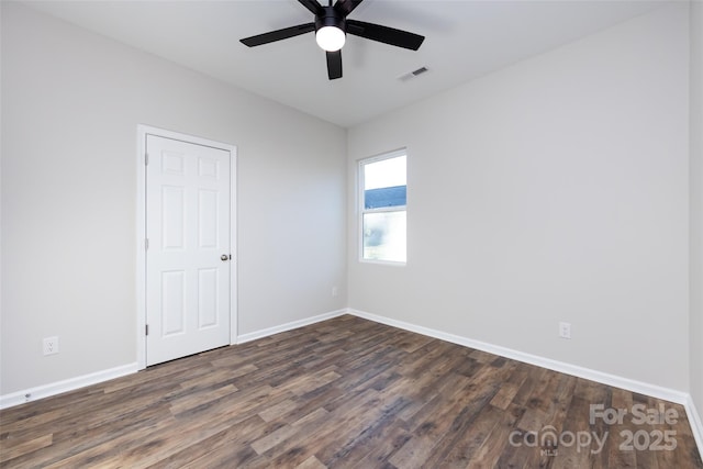 spare room featuring dark hardwood / wood-style flooring and ceiling fan