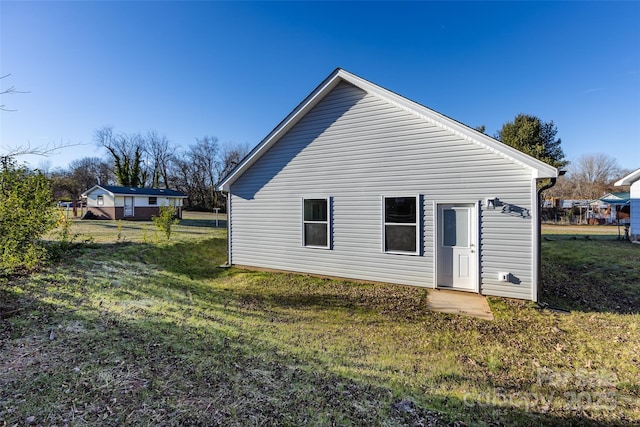 back of property featuring a yard