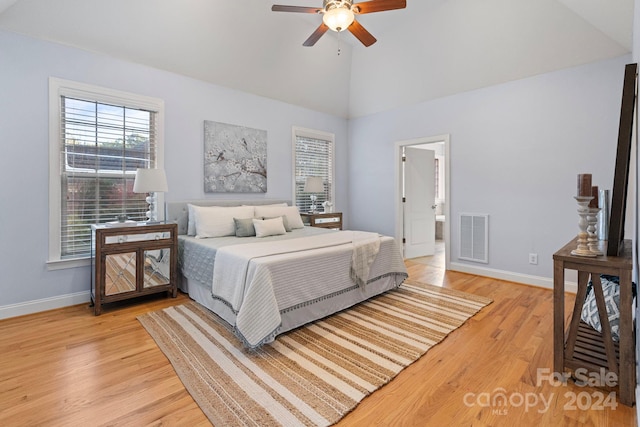 bedroom with connected bathroom, high vaulted ceiling, light hardwood / wood-style flooring, and ceiling fan