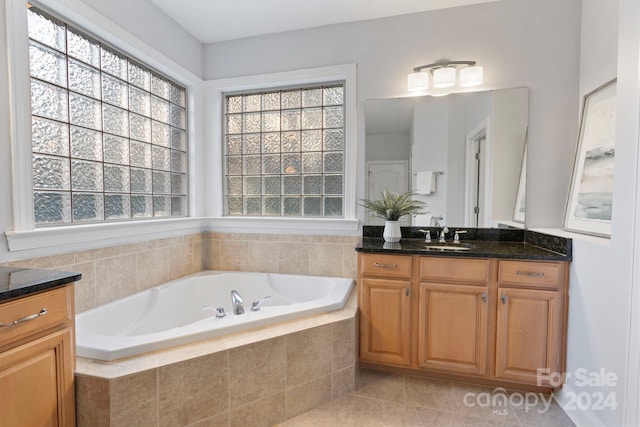 bathroom with vanity, a relaxing tiled tub, tile patterned floors, and a wealth of natural light