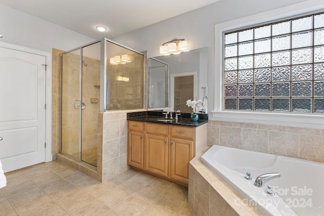 bathroom featuring shower with separate bathtub, vanity, and tile patterned floors