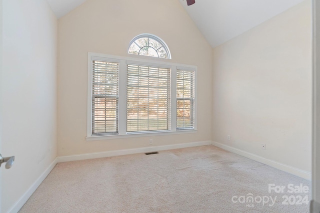 unfurnished room with light colored carpet, high vaulted ceiling, and ceiling fan