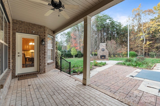 view of patio / terrace featuring ceiling fan and exterior fireplace