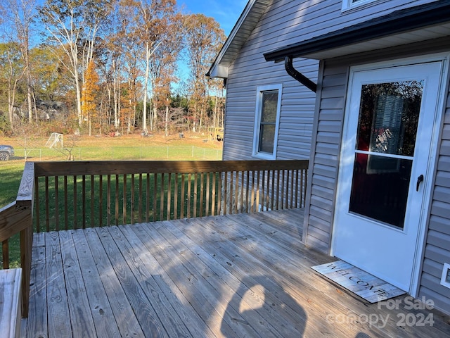 wooden terrace featuring a lawn