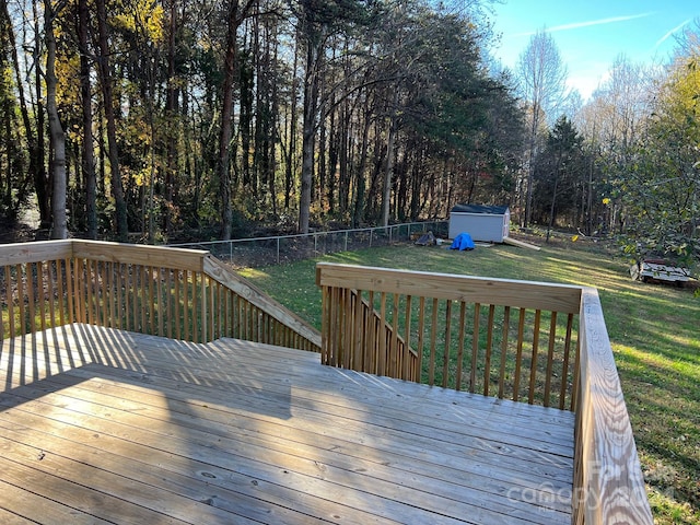 wooden terrace featuring a storage unit and a yard