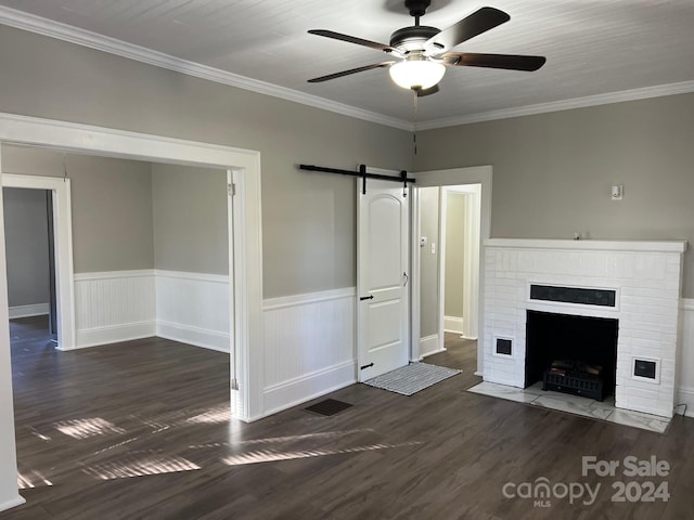 unfurnished living room with a fireplace, dark hardwood / wood-style floors, ceiling fan, and crown molding