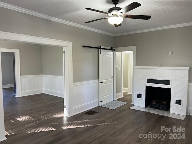 4541 Hall Dairy Rd, Claremont, NC 28610 - unfurnished living room with wood finished floors, ceiling fan, a barn door, a wainscoted wall, and crown molding