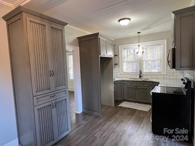 kitchen featuring pendant lighting, sink, tasteful backsplash, dark hardwood / wood-style flooring, and a chandelier