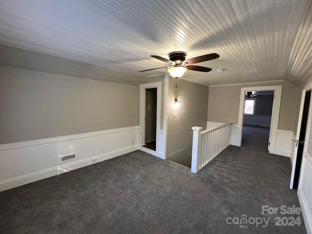 unfurnished room featuring dark carpet, ceiling fan, and lofted ceiling