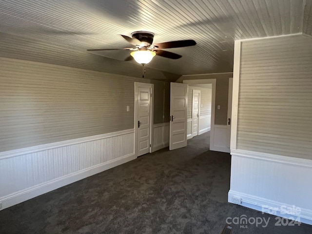 empty room featuring dark colored carpet and ceiling fan