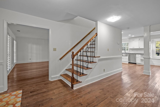 stairs featuring wood-type flooring and sink