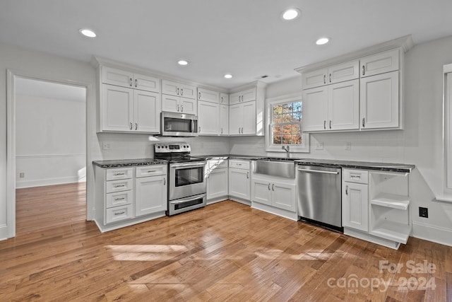 kitchen featuring white cabinets, stainless steel appliances, light hardwood / wood-style floors, and sink