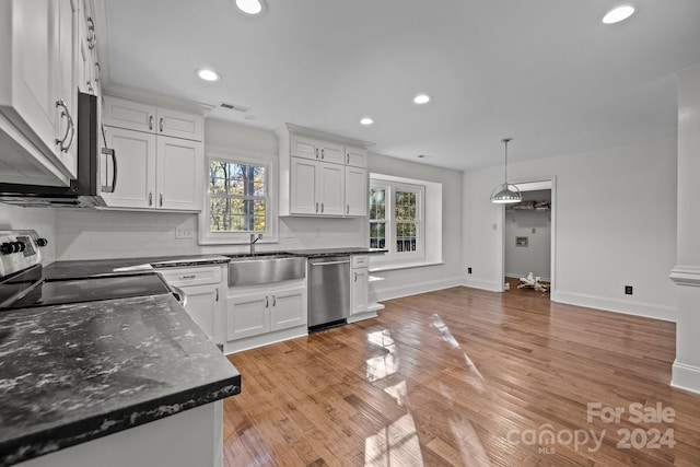 kitchen with appliances with stainless steel finishes, white cabinets, and a wealth of natural light