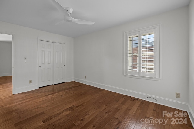 unfurnished bedroom featuring dark hardwood / wood-style flooring, a closet, and ceiling fan