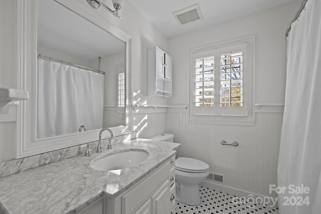 bathroom featuring tile patterned flooring, vanity, and toilet