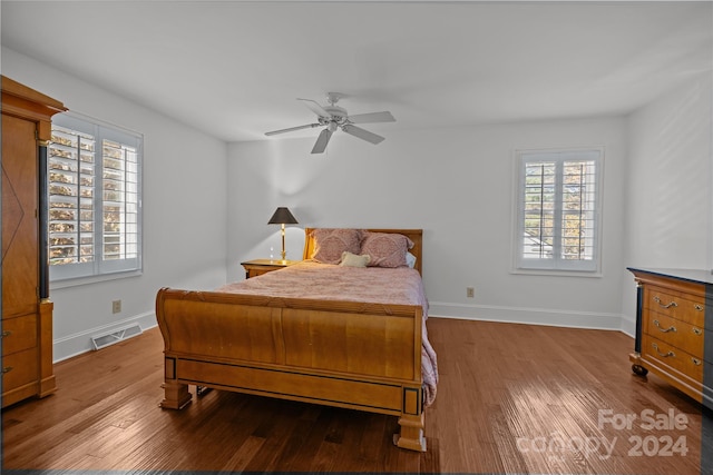 bedroom featuring ceiling fan, wood-type flooring, and multiple windows