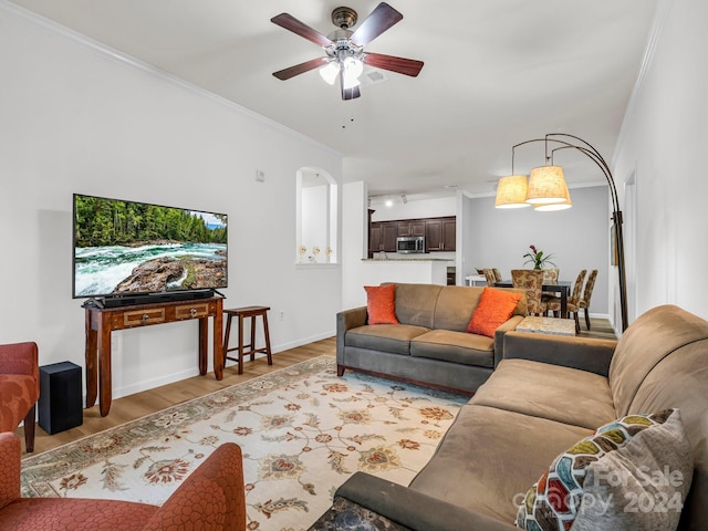 living room featuring crown molding, light hardwood / wood-style flooring, and ceiling fan