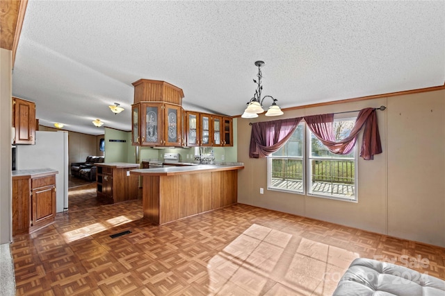 kitchen with a breakfast bar, lofted ceiling, parquet floors, a textured ceiling, and kitchen peninsula