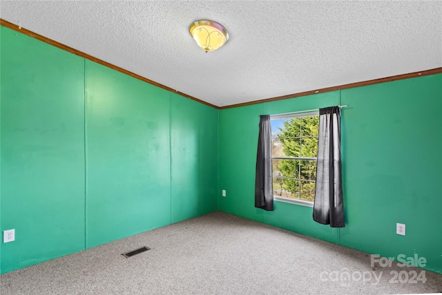 unfurnished room featuring carpet flooring, a textured ceiling, and ornamental molding