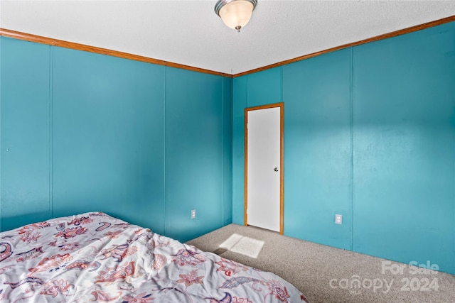 unfurnished bedroom featuring a textured ceiling, carpet floors, and crown molding