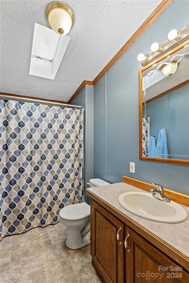 bathroom with vanity, a textured ceiling, a skylight, and toilet