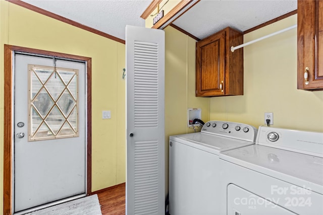 clothes washing area featuring cabinets, separate washer and dryer, light hardwood / wood-style flooring, crown molding, and a textured ceiling