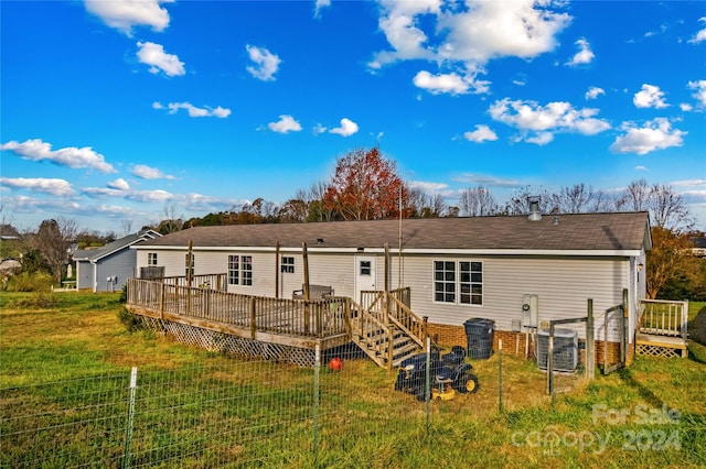 back of house featuring a lawn and a wooden deck