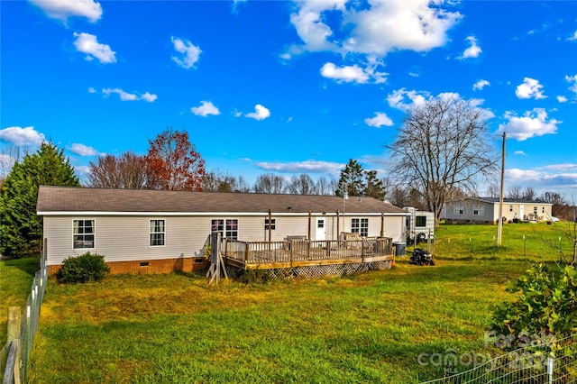 back of house featuring a wooden deck and a yard