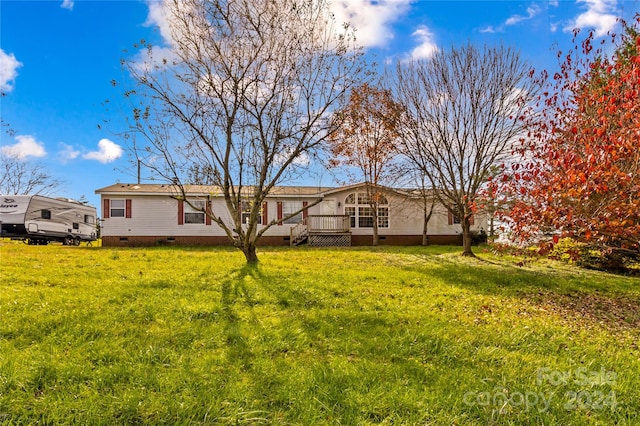 back of house with a wooden deck and a lawn