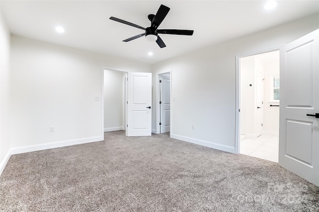 unfurnished bedroom featuring connected bathroom, ceiling fan, and light colored carpet