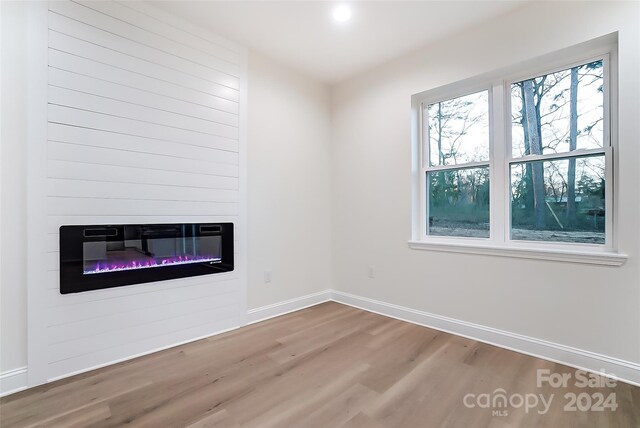 unfurnished room featuring hardwood / wood-style flooring and a fireplace