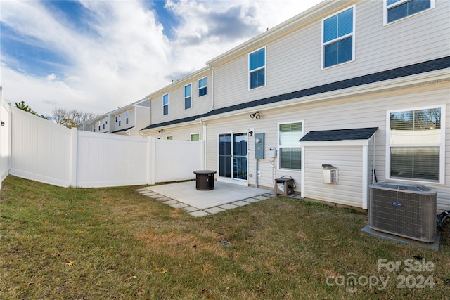 rear view of house featuring a lawn, cooling unit, and a patio