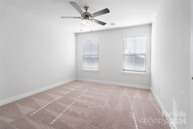 carpeted spare room with ceiling fan