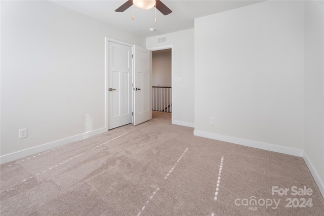 carpeted spare room featuring ceiling fan