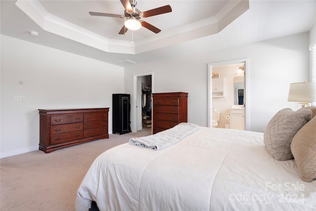 carpeted bedroom featuring ensuite bathroom, a raised ceiling, ceiling fan, a spacious closet, and a closet