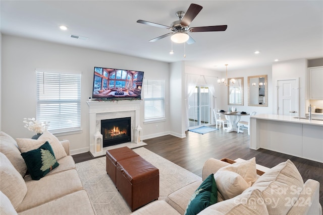 living room featuring sink, ceiling fan with notable chandelier, and hardwood / wood-style flooring