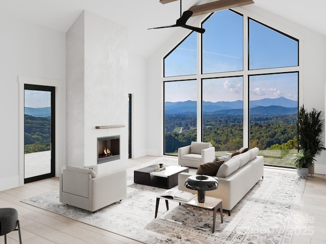3 Bridgeway Dr Unit 38, Candler, NC 28715 - living room with high vaulted ceiling, a mountain view, wood finished floors, a lit fireplace, and a ceiling fan