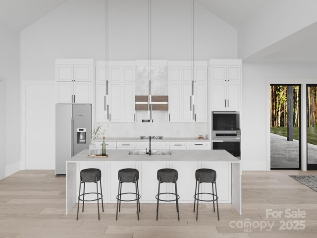 3 Bridgeway Dr Unit 38, Candler, NC 28715 - kitchen featuring high vaulted ceiling, stainless steel appliances, a kitchen bar, tasteful backsplash, and a center island with sink