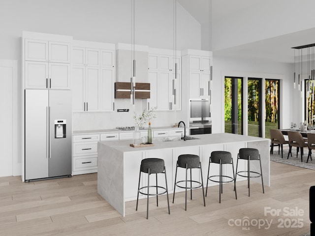 3 Bridgeway Dr Unit 38, Candler, NC 28715 - kitchen with stainless steel appliances, high vaulted ceiling, a center island with sink, a sink, and a kitchen breakfast bar