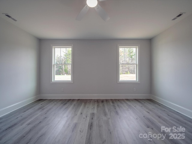 unfurnished room featuring ceiling fan, light hardwood / wood-style floors, and a wealth of natural light