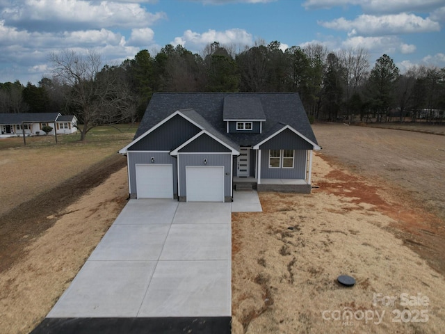 view of front of house with concrete driveway, a garage, and roof with shingles