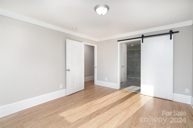 3700 Pinecrest Dr, Gastonia, NC 28056 - unfurnished bedroom with wood finished floors, baseboards, a barn door, and ensuite bathroom