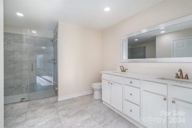 bathroom with vanity, toilet, and a shower with door