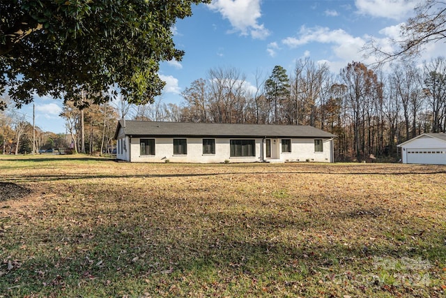 ranch-style home with a front yard, an outdoor structure, and a garage