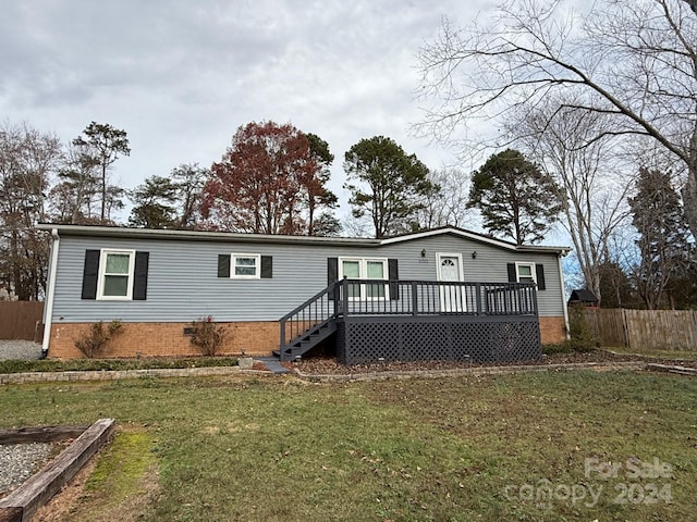 back of property featuring a yard and a wooden deck