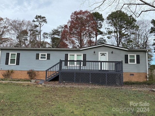 rear view of house with a deck and a lawn