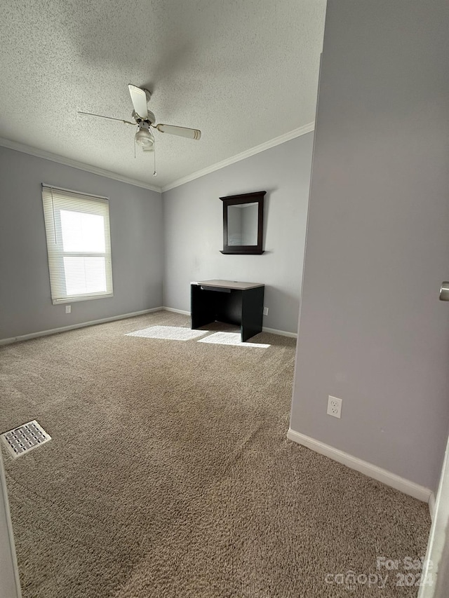 unfurnished living room with ceiling fan, carpet, a textured ceiling, and ornamental molding